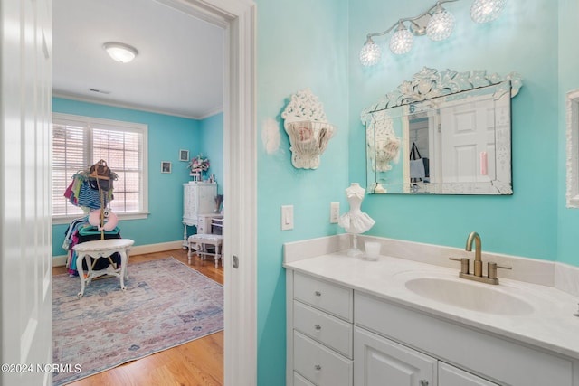 bathroom with vanity, ornamental molding, and hardwood / wood-style floors