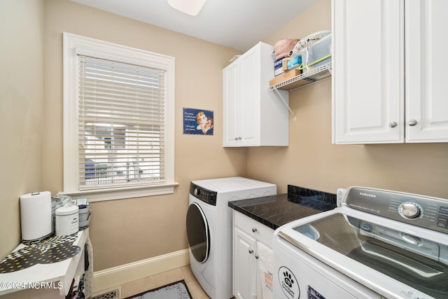 laundry room with cabinets, washing machine and dryer, and tile patterned flooring