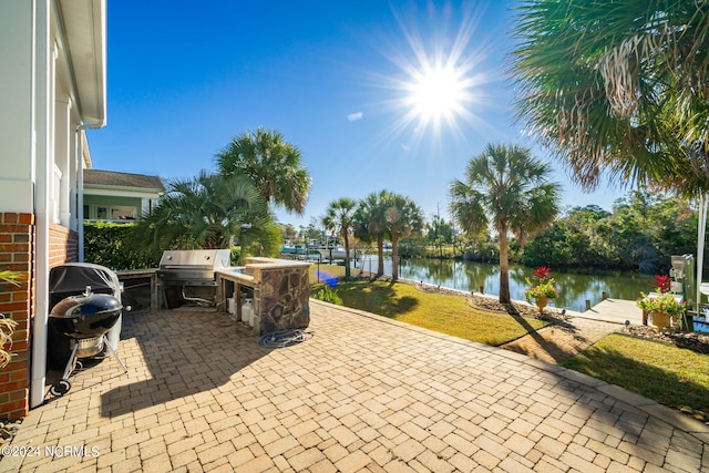 view of patio with a water view and a grill