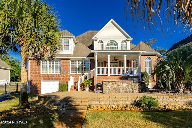 view of front of home featuring a porch, ceiling fan, and a front lawn