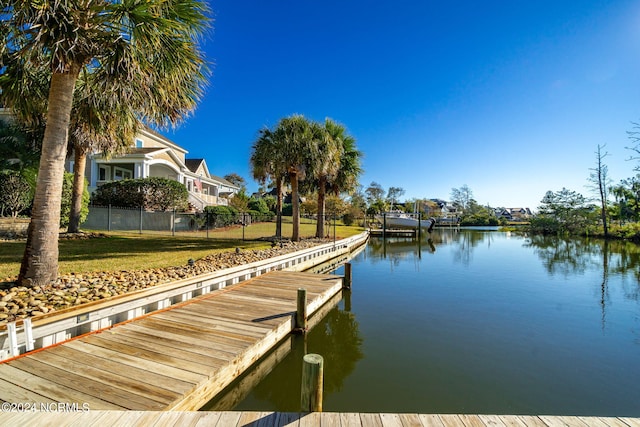 dock area featuring a water view and a lawn