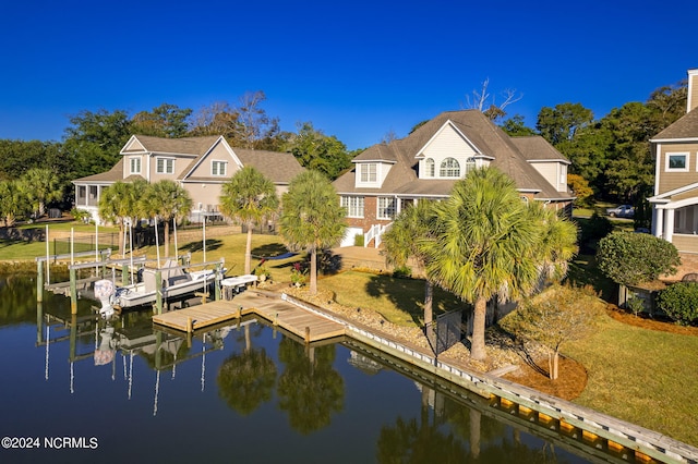 back of house with a water view and a lawn