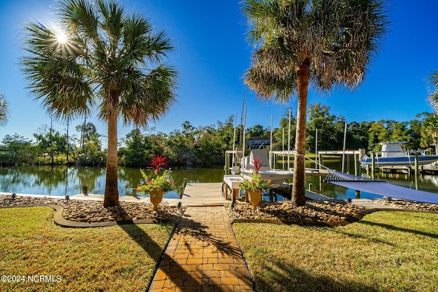 view of dock featuring a lawn and a water view