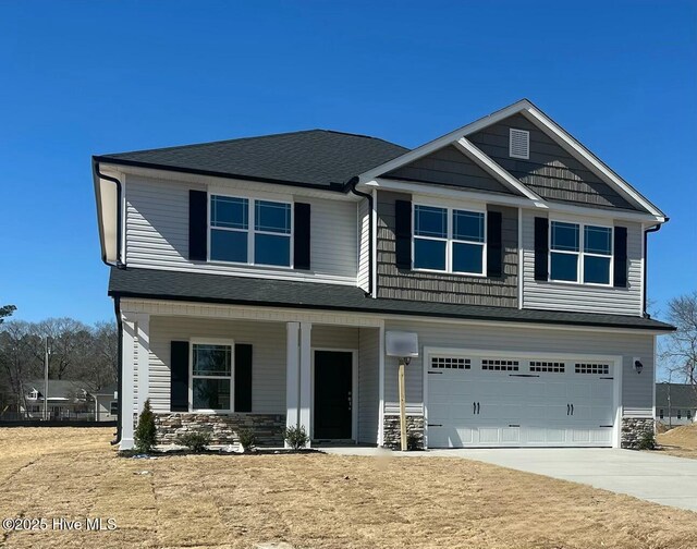 craftsman-style home with a front lawn and a garage