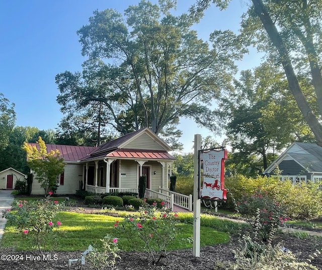 view of front of house featuring a standing seam roof, metal roof, and a front lawn