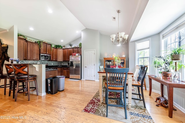 220 Everett Yopp Dr, Sneads Ferry, NC 28460 - dining area with light wood-style floors, a chandelier, and lofted ceiling