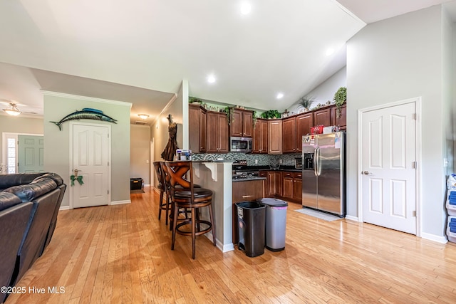 220 Everett Yopp Dr, Sneads Ferry, NC 28460 - kitchen with stainless steel appliances, a kitchen bar, dark countertops, a peninsula, and tasteful backsplash