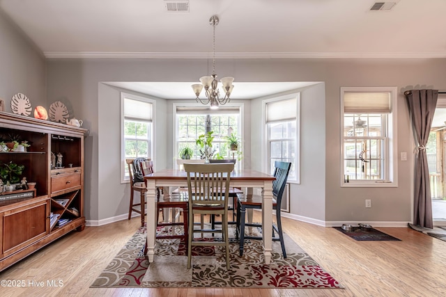 220 Everett Yopp Dr, Sneads Ferry, NC 28460 - dining space with light wood-type flooring, crown molding, and a chandelier