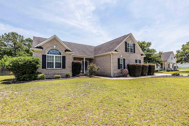220 Everett Yopp Dr, Sneads Ferry, NC 28460 - view of front of house with brick siding, a front yard, and roof with shingles
