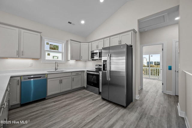 kitchen featuring sink, gray cabinets, light wood-type flooring, and appliances with stainless steel finishes