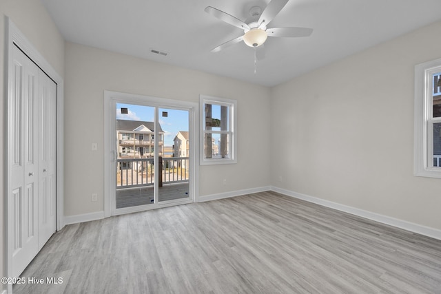 unfurnished bedroom with a closet, access to exterior, ceiling fan, and light hardwood / wood-style flooring