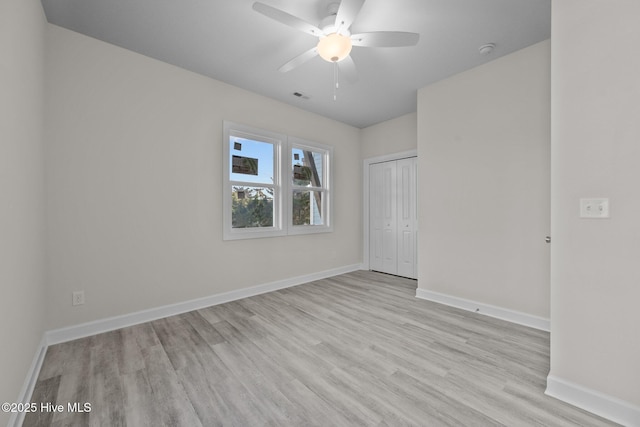 empty room with ceiling fan and light hardwood / wood-style flooring