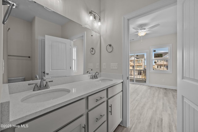 bathroom featuring wood-type flooring, ceiling fan, vanity, and toilet