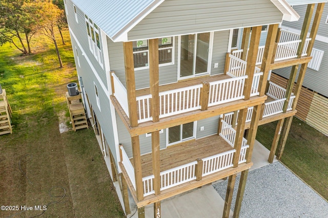 exterior space featuring a balcony, central AC, and a lawn