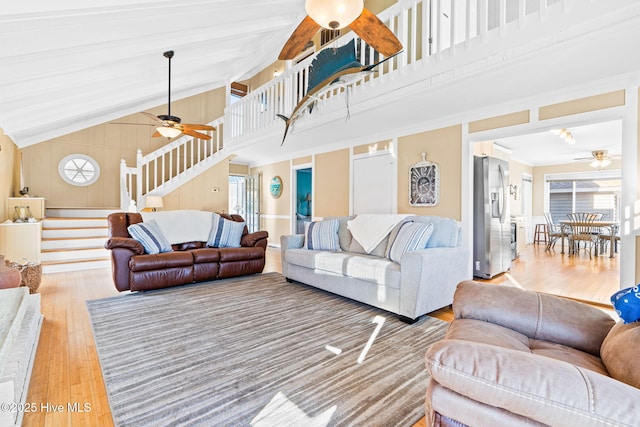 living room featuring ceiling fan, high vaulted ceiling, and wood-type flooring