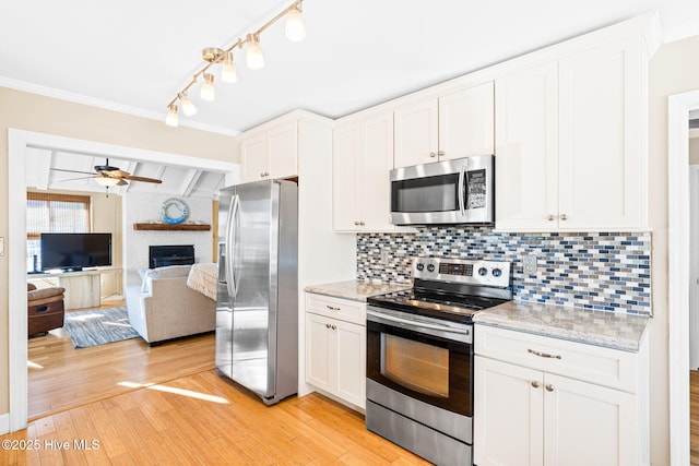 kitchen with white cabinets, decorative backsplash, light hardwood / wood-style flooring, and appliances with stainless steel finishes