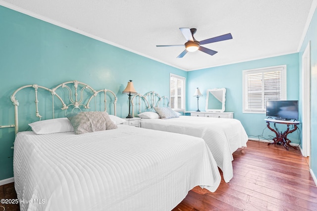 27 Newport St, Ocean Isle Beach, NC 28469 - bedroom with crown molding, multiple windows, hardwood / wood-style floors, and a ceiling fan