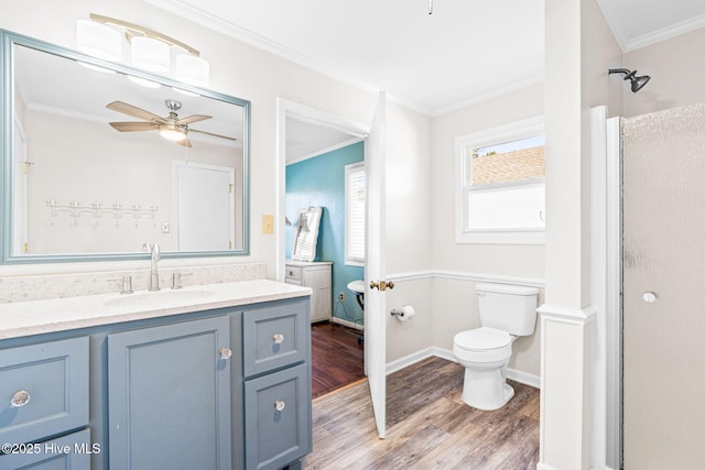 bathroom with hardwood / wood-style floors, ceiling fan, toilet, vanity, and crown molding