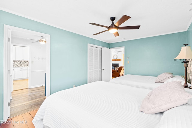 27 Newport St, Ocean Isle Beach, NC 28469 - bedroom featuring hardwood / wood-style floors, crown molding, a closet, and a ceiling fan