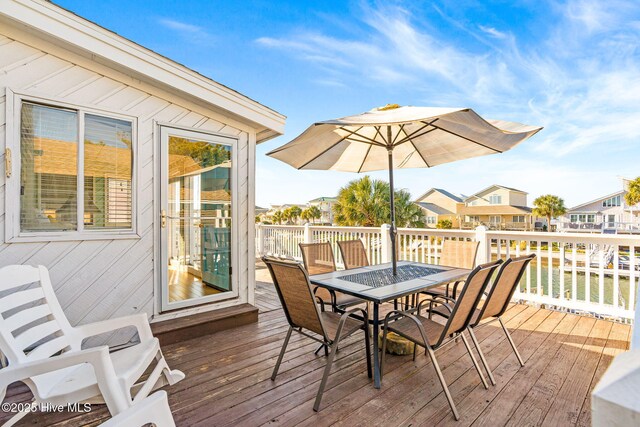27 Newport St, Ocean Isle Beach, NC 28469 - wooden terrace featuring outdoor dining area and a residential view
