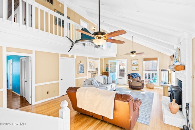 27 Newport St, Ocean Isle Beach, NC 28469 - living area featuring wood finished floors, beamed ceiling, a ceiling fan, a fireplace, and a wainscoted wall