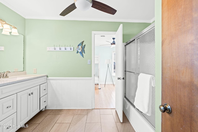 27 Newport St, Ocean Isle Beach, NC 28469 - bathroom featuring ceiling fan, crown molding, wainscoting, bath / shower combo with glass door, and vanity