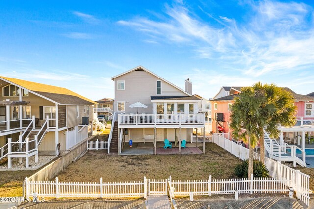 27 Newport St, Ocean Isle Beach, NC 28469 - rear view of house featuring a patio area, a wooden deck, stairs, and a residential view