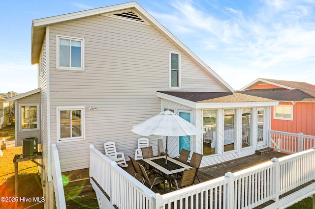 27 Newport St, Ocean Isle Beach, NC 28469 - back of property featuring a deck, central AC unit, outdoor dining space, and a sunroom