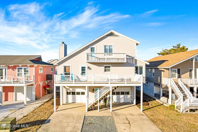 27 Newport St, Ocean Isle Beach, NC 28469 - rear view of property featuring stairway, an attached garage, concrete driveway, and a balcony
