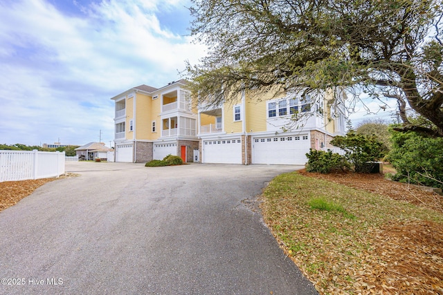 116 Salter Path Rd Unit 102Seabrook, Pine Knoll Shores, NC 28512 - view of front of property featuring a garage, driveway, brick siding, and fence