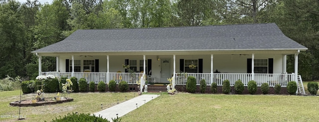 view of front of property with ceiling fan, roof with shingles, a front lawn, and covered porch