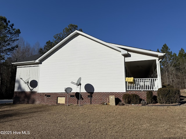 view of side of property featuring a lawn and crawl space