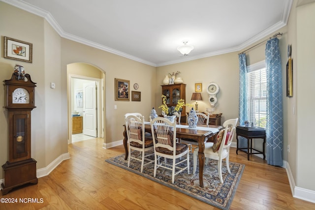 dining area with crown molding and light wood-type flooring