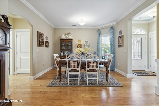 dining space with crown molding and light hardwood / wood-style flooring