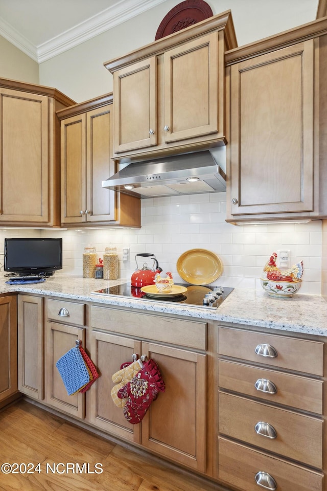 kitchen with light stone countertops, tasteful backsplash, electric stovetop, crown molding, and light wood-type flooring