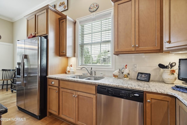 kitchen with appliances with stainless steel finishes, a wealth of natural light, crown molding, and sink