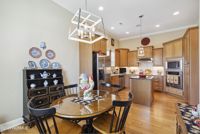 dining area featuring light hardwood / wood-style floors, crown molding, and an inviting chandelier