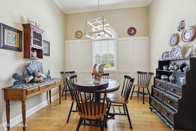 dining room featuring light wood-type flooring, an inviting chandelier, and ornamental molding