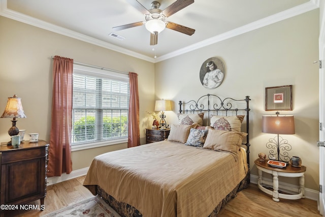 bedroom featuring ceiling fan, light hardwood / wood-style floors, and crown molding