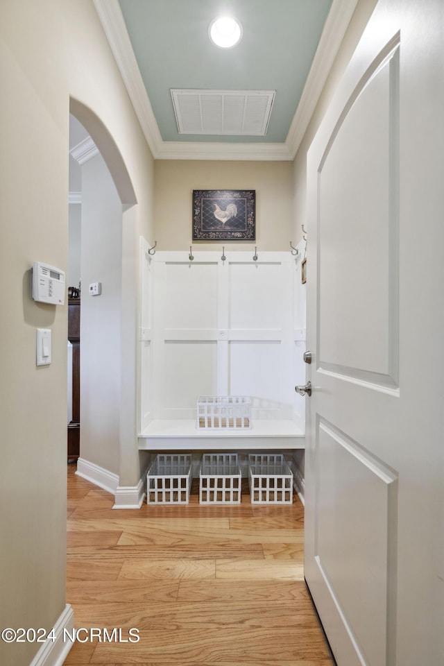 mudroom with ornamental molding and hardwood / wood-style flooring