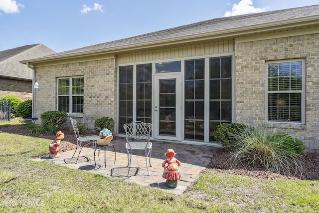 back of property with a lawn and a patio