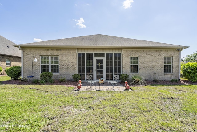 back of property featuring a patio area and a yard