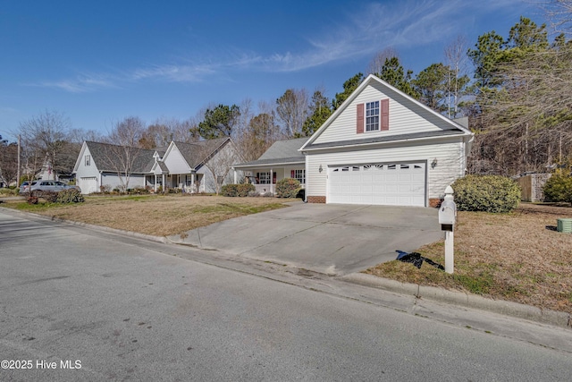 view of front of house featuring a garage, concrete driveway, and a front lawn