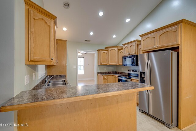 kitchen with stainless steel fridge with ice dispenser, light brown cabinets, lofted ceiling, and range