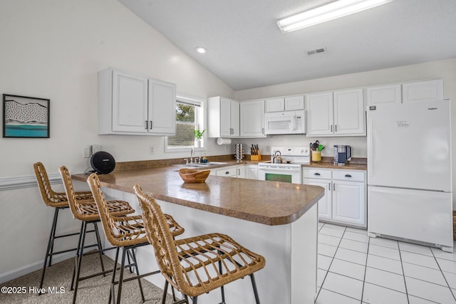 kitchen featuring vaulted ceiling, kitchen peninsula, white cabinets, and white appliances