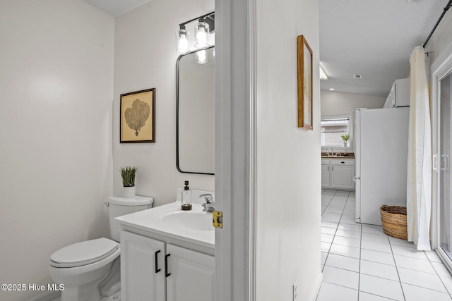 bathroom featuring tile patterned flooring, vanity, toilet, and vaulted ceiling