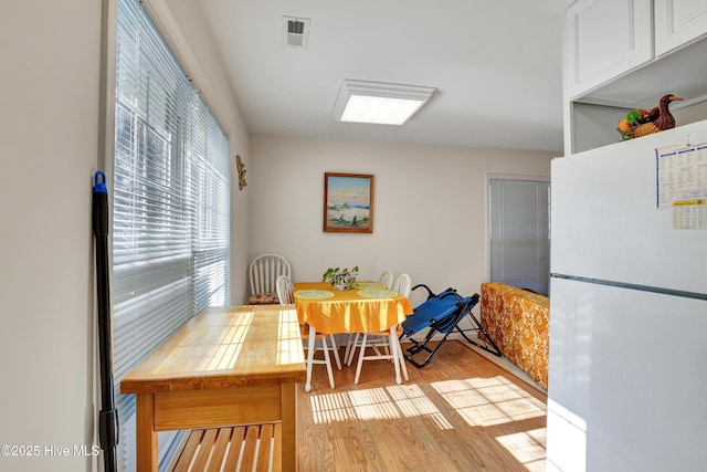 dining space featuring visible vents and wood finished floors