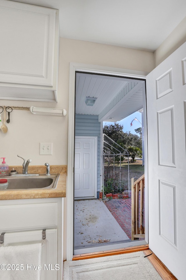 doorway to outside with sink and light hardwood / wood-style flooring