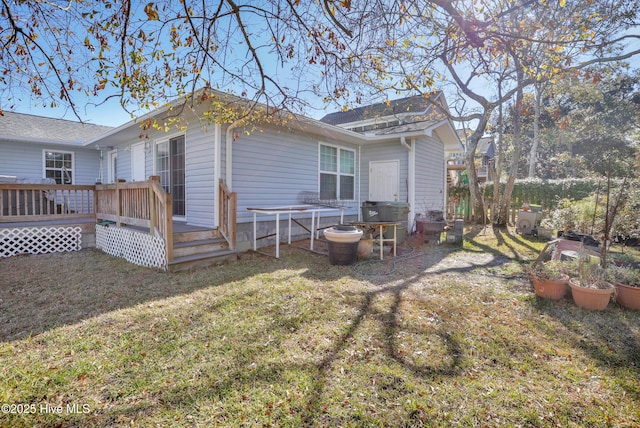 rear view of property featuring a deck and a lawn