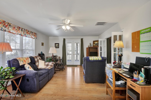 living room with ceiling fan, light hardwood / wood-style floors, and french doors